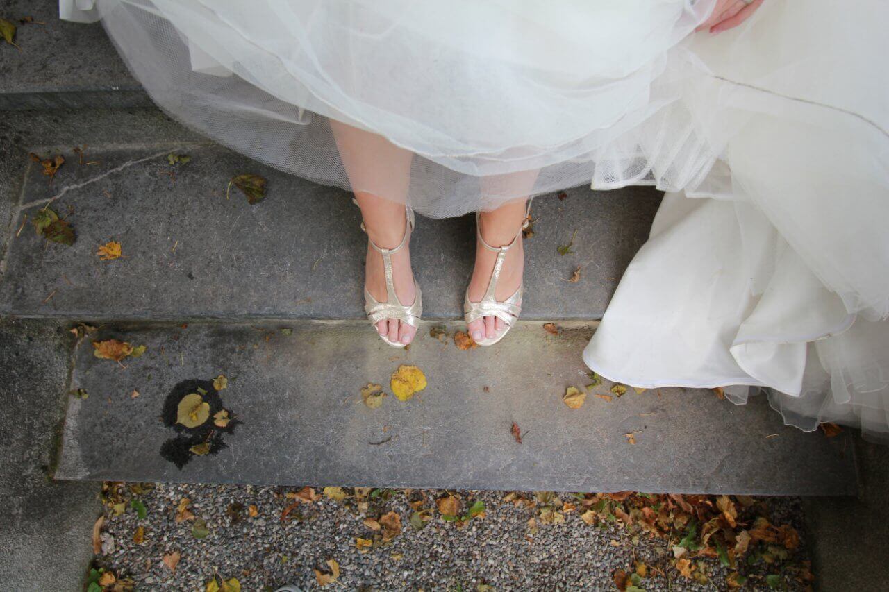 A bride's footwear while she's standing on a stoop